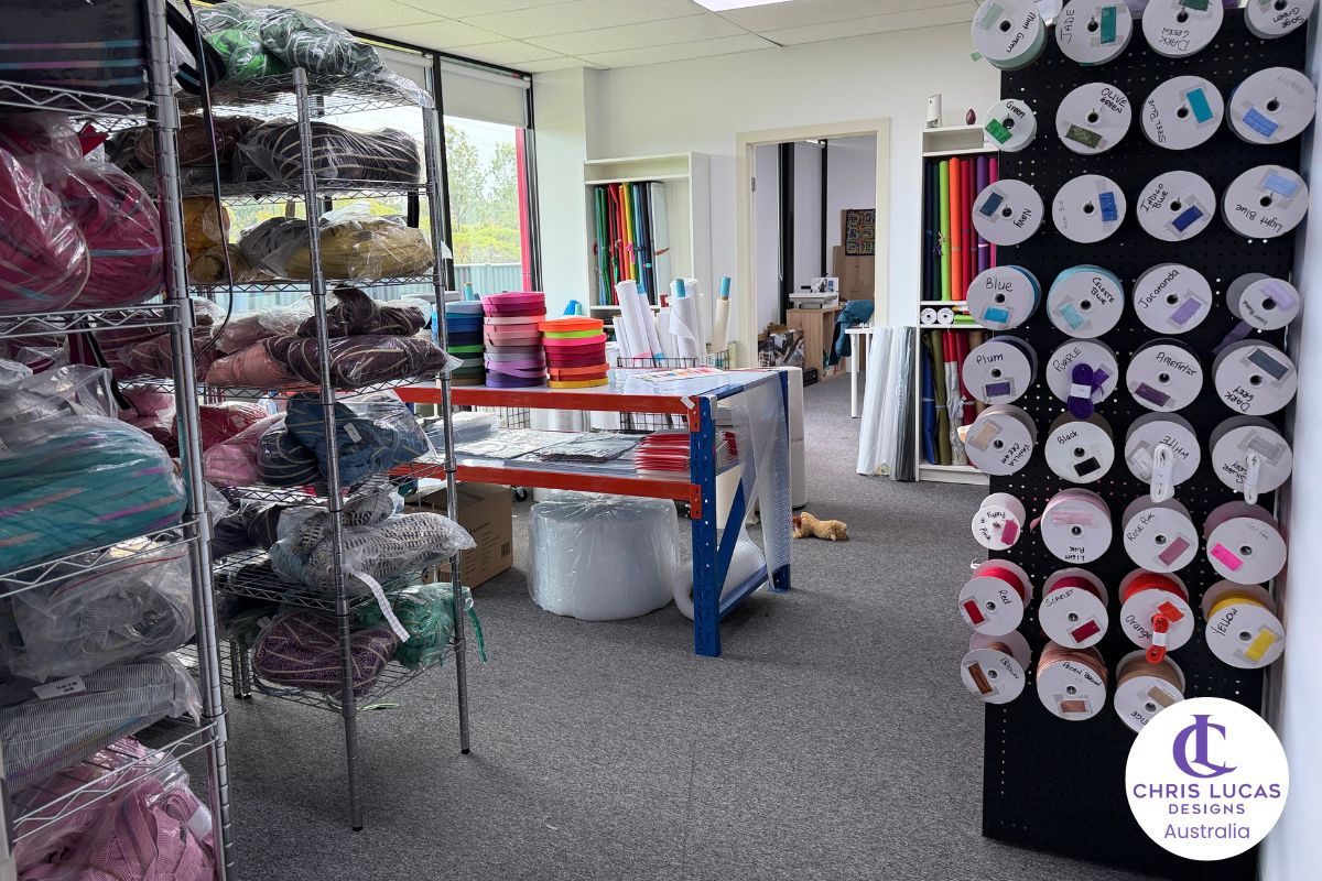 Cutting room area with interfacing, webbing, zipper tape, waterproof canvas and fold over elastic at Chris Lucas Designs showroom